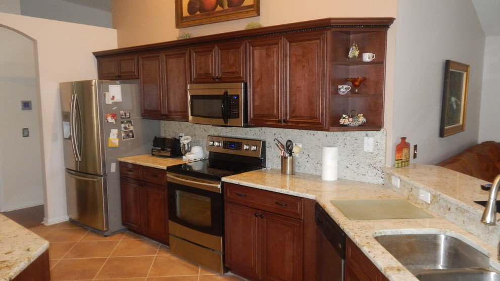 Mid-sized elegant galley eat-in kitchen photo in Orlando with raised-panel cabinets and dark wood cabinets