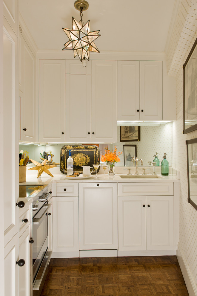Klassische Küche mit Unterbauwaschbecken, Schrankfronten mit vertiefter Füllung, weißen Schränken und braunem Holzboden in Boston