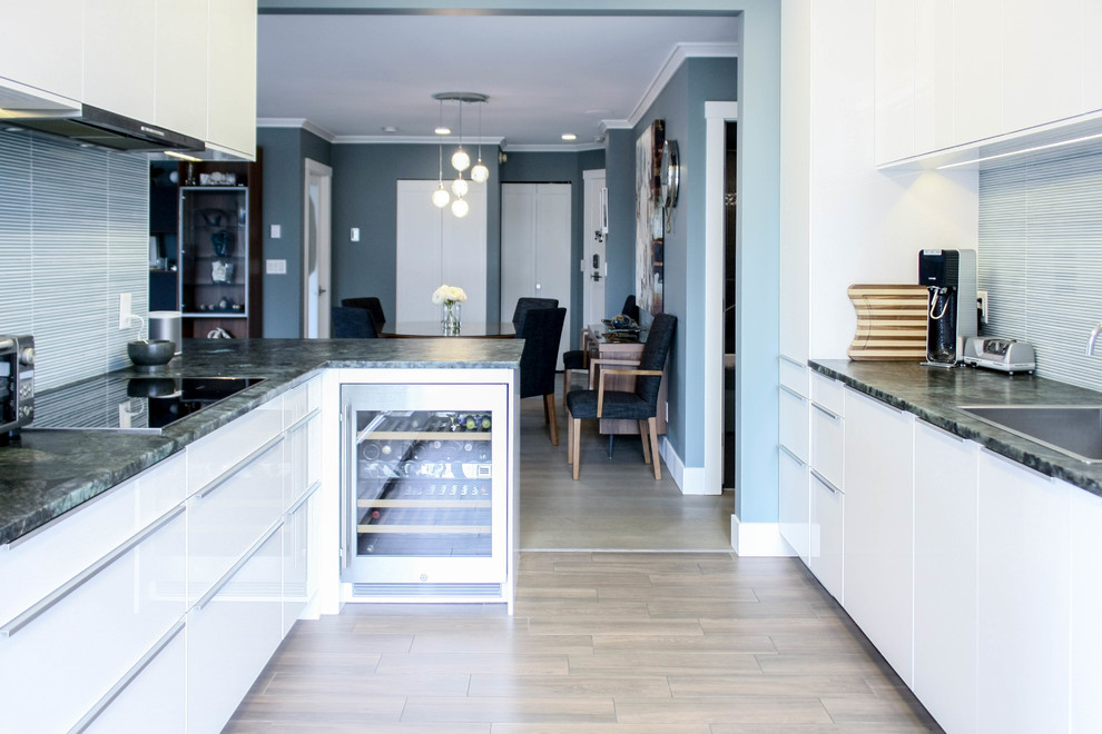 Moderne Küche mit Waschbecken, flächenbündigen Schrankfronten, weißen Schränken, Granit-Arbeitsplatte, Küchenrückwand in Blau, Rückwand aus Keramikfliesen, Küchengeräten aus Edelstahl, Keramikboden und Halbinsel in Vancouver