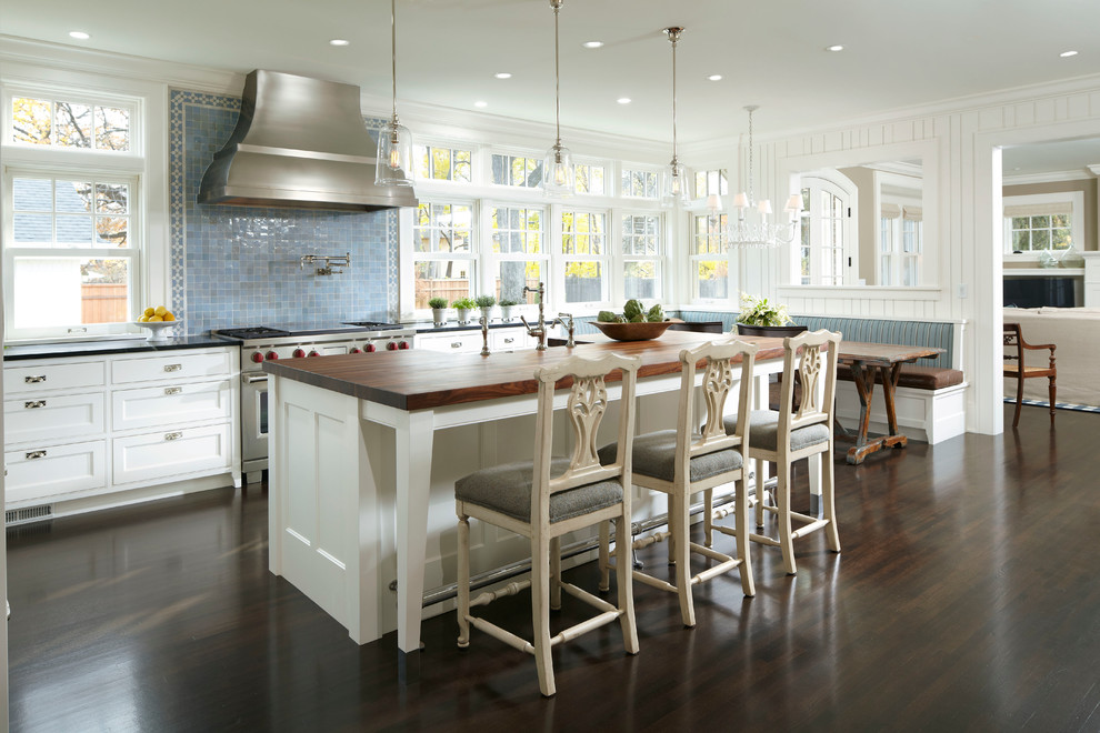 Klassische Wohnküche in L-Form mit Schrankfronten im Shaker-Stil, weißen Schränken, Küchenrückwand in Blau, Küchengeräten aus Edelstahl, dunklem Holzboden, Kücheninsel und Rückwand aus Mosaikfliesen in Minneapolis