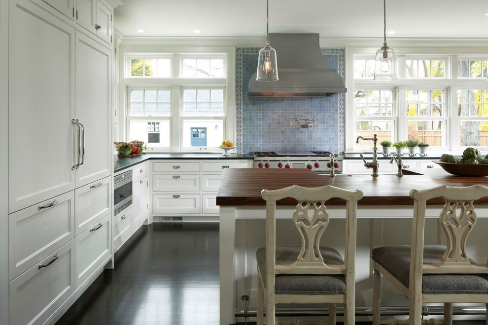 Источник вдохновения для домашнего уюта: кухня в классическом стиле с белыми фасадами, синим фартуком, техникой из нержавеющей стали, темным паркетным полом и островом