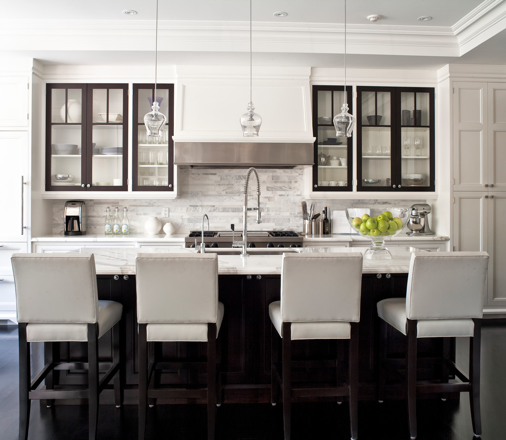 Example of a transitional galley kitchen design in Toronto with white backsplash, marble countertops, an undermount sink, glass-front cabinets, paneled appliances, marble backsplash and white countertops