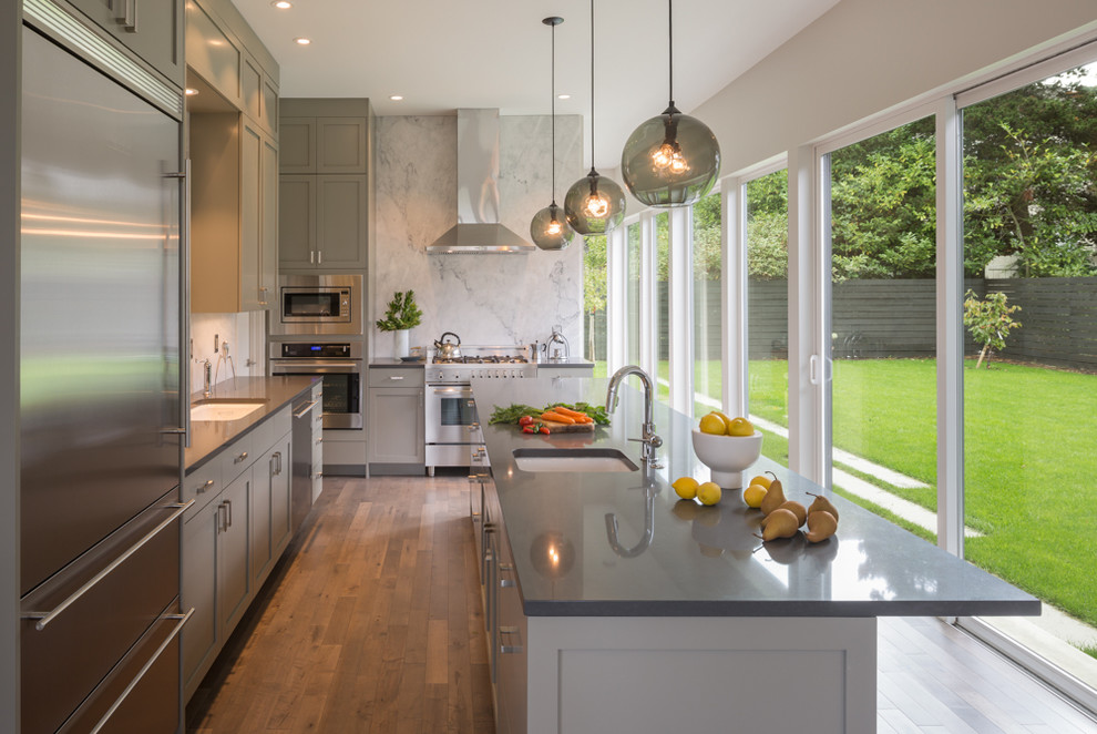 Klassische Küche in L-Form mit Unterbauwaschbecken, Schrankfronten im Shaker-Stil, grauen Schränken, Küchengeräten aus Edelstahl, dunklem Holzboden und Kücheninsel in Seattle