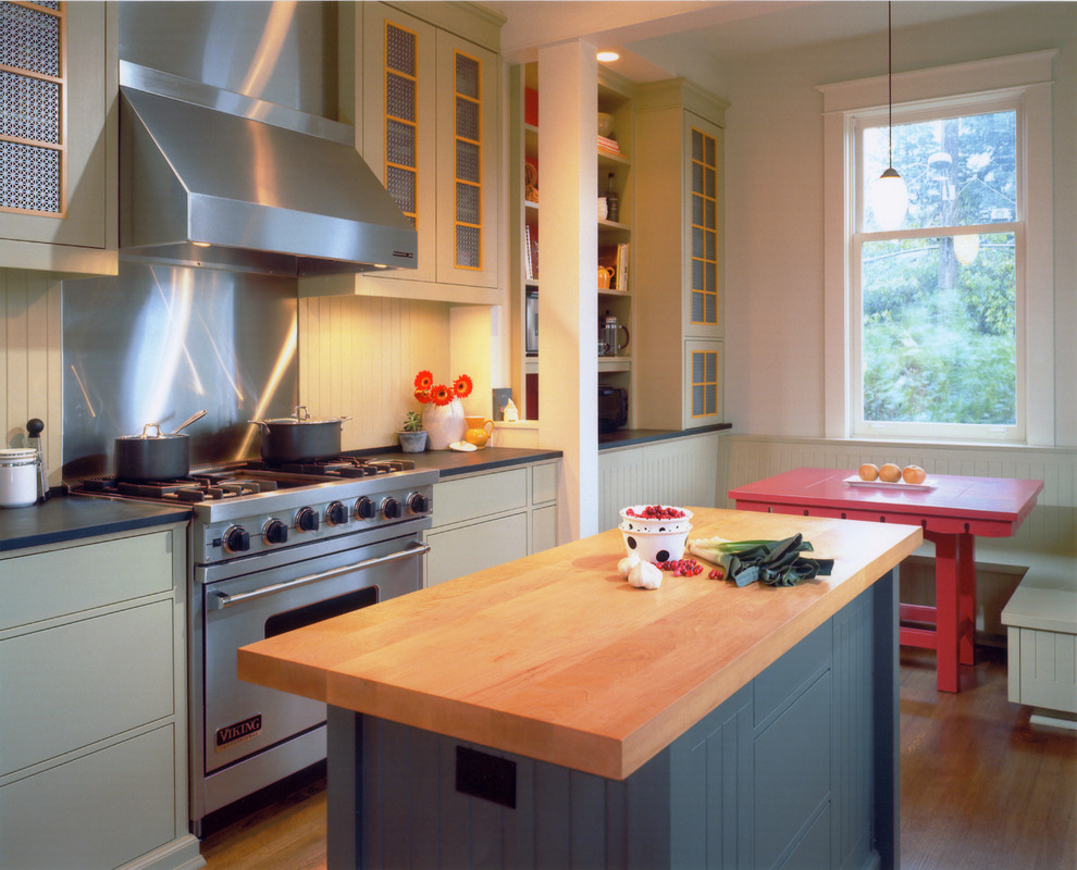 Foto de cocina actual con electrodomésticos de acero inoxidable, una isla, suelo marrón y encimeras azules
