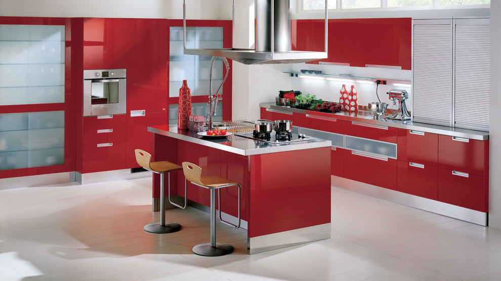 Modern inredning av ett litet kök, med en dubbel diskho, luckor med upphöjd panel, röda skåp, bänkskiva i rostfritt stål, vitt stänkskydd, glaspanel som stänkskydd, rostfria vitvaror, målat trägolv och flera köksöar