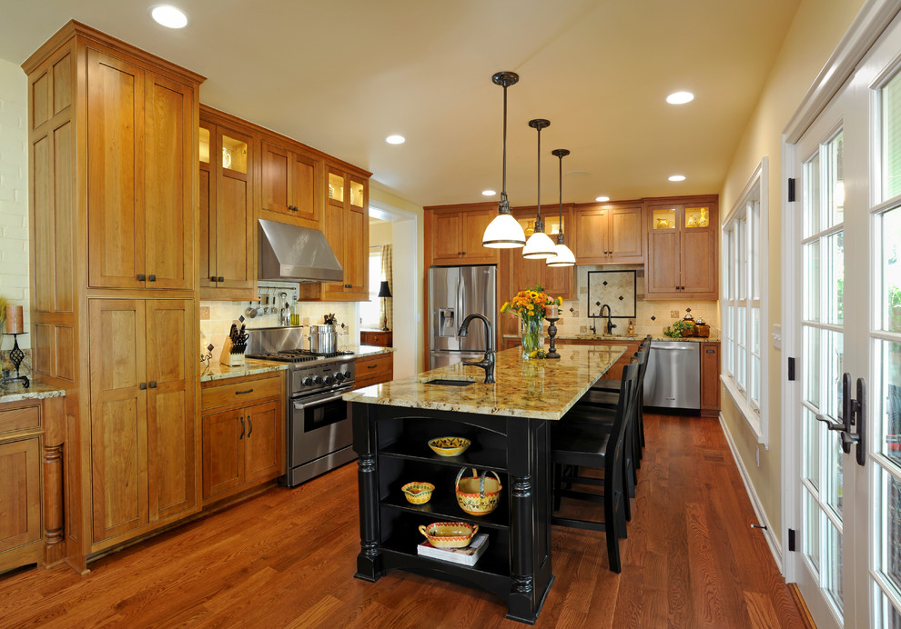 Imagen de cocina tradicional con armarios estilo shaker, puertas de armario de madera oscura, salpicadero beige y electrodomésticos de acero inoxidable