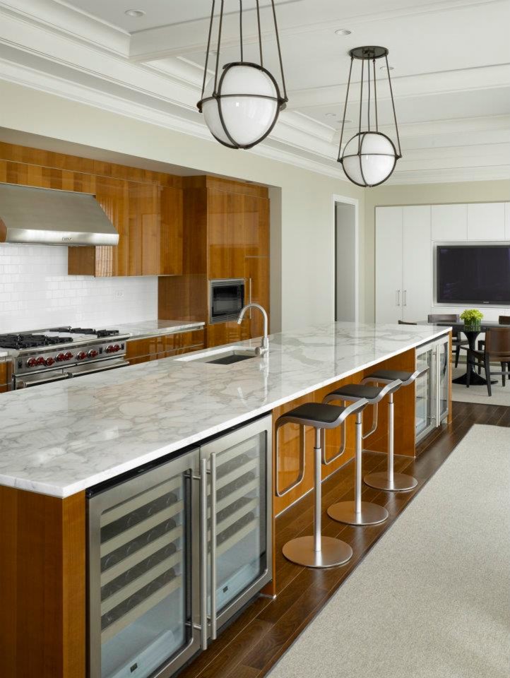 Immagine di una grande cucina minimalista con lavello sottopiano, ante lisce, ante in legno scuro, elettrodomestici in acciaio inossidabile, parquet scuro, top in marmo e paraspruzzi bianco