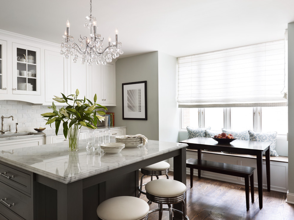Eat-in kitchen - mid-sized traditional l-shaped dark wood floor and brown floor eat-in kitchen idea in Chicago with an undermount sink, white cabinets, marble countertops, white backsplash, marble backsplash, an island and beaded inset cabinets