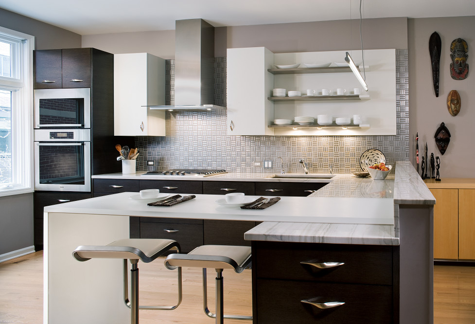 Bild på ett mellanstort funkis kök, med en enkel diskho, släta luckor, skåp i mörkt trä, granitbänkskiva, stänkskydd med metallisk yta, stänkskydd i metallkakel, rostfria vitvaror, ljust trägolv och en halv köksö