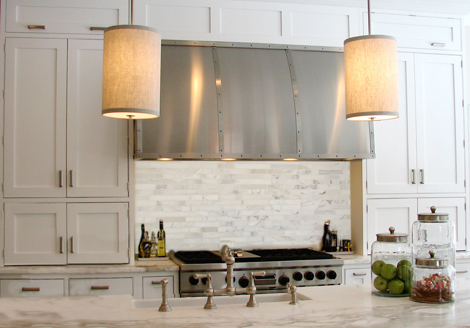 Klassisk inredning av ett stort kök, med en rustik diskho, släta luckor, vita skåp, marmorbänkskiva, vitt stänkskydd, stänkskydd i stickkakel, rostfria vitvaror, linoleumgolv och en köksö