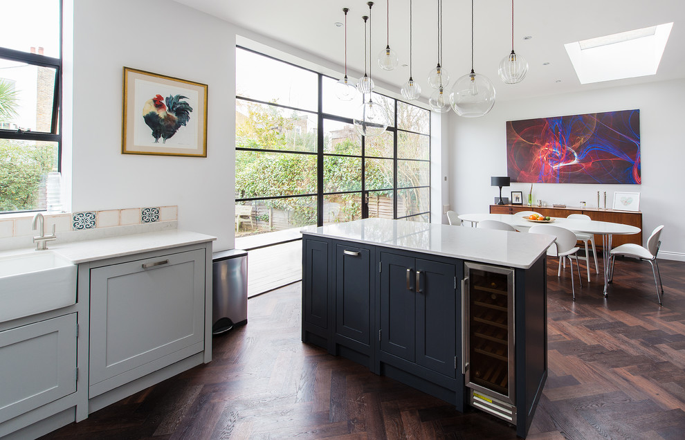 Offene, Mittelgroße Klassische Küche in U-Form mit Landhausspüle, Schrankfronten im Shaker-Stil, grauen Schränken, dunklem Holzboden und Kücheninsel in London