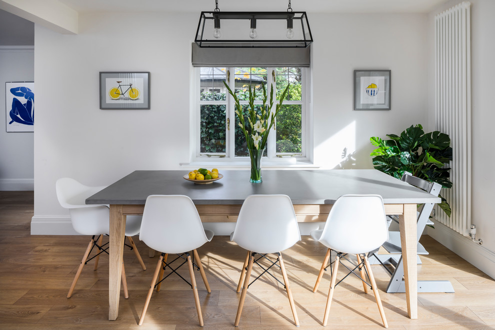 This is an example of a medium sized contemporary open plan dining room in Surrey with light hardwood flooring and beige floors.