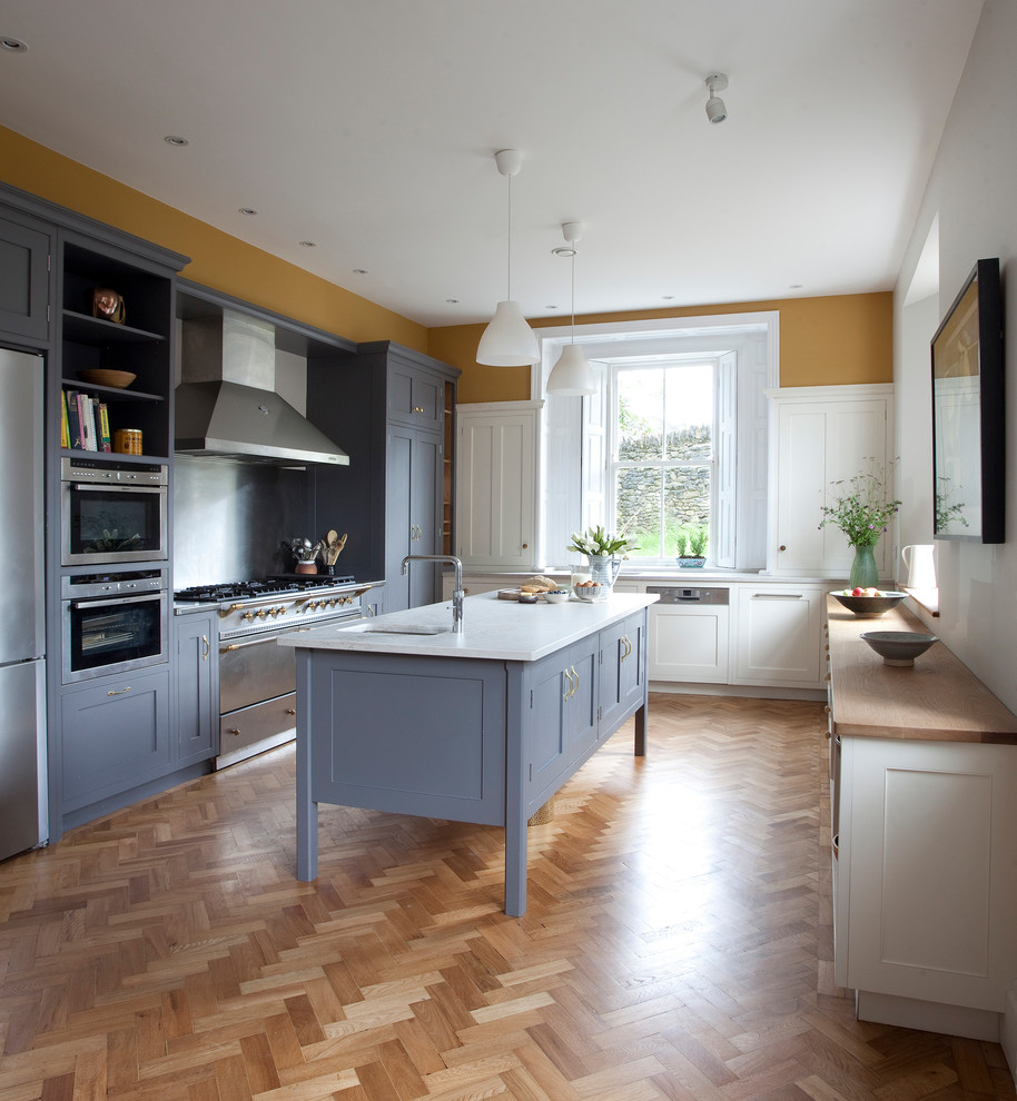 Example of a mid-sized transitional u-shaped dark wood floor eat-in kitchen design in Dublin with a double-bowl sink, shaker cabinets, gray cabinets, quartzite countertops, window backsplash, stainless steel appliances and an island