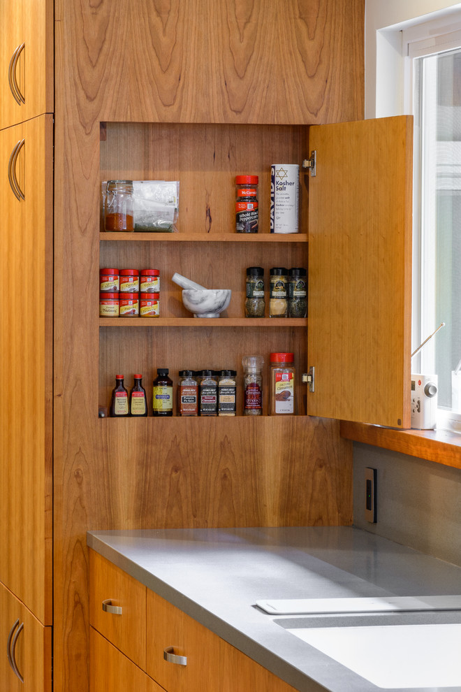 This is an example of a large contemporary l-shaped kitchen pantry in Los Angeles with a double-bowl sink, flat-panel cabinets, medium wood cabinets, engineered stone countertops, beige splashback, mosaic tiled splashback, stainless steel appliances, medium hardwood flooring and an island.