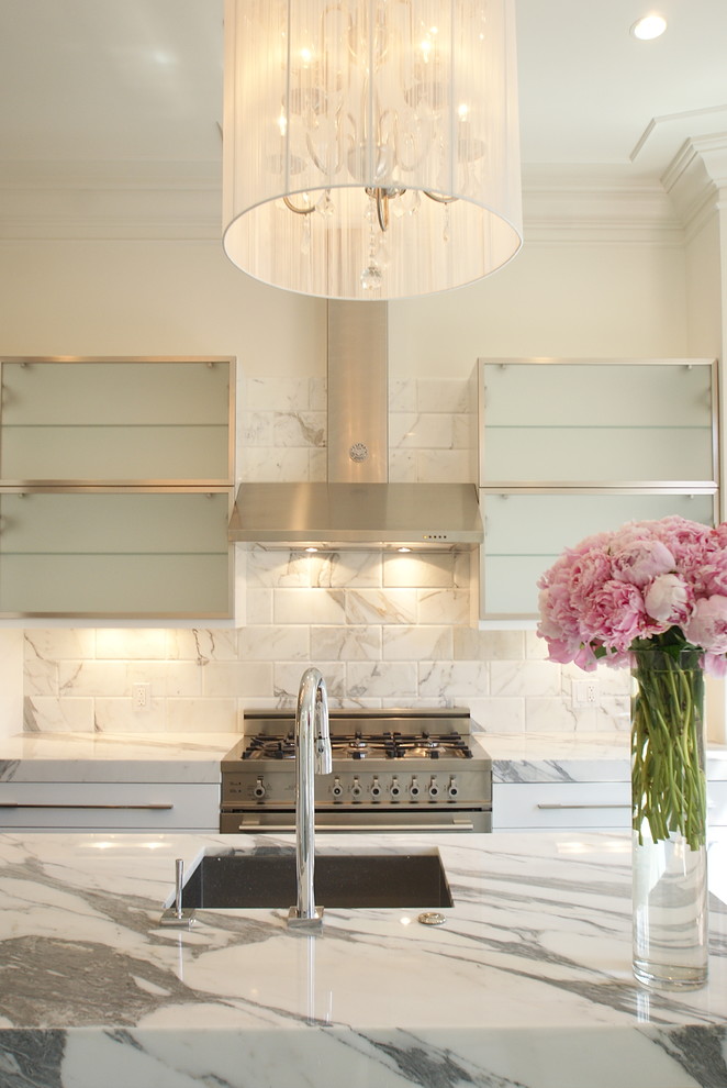 Photo of a contemporary kitchen in Boston with stainless steel appliances, marble worktops, a single-bowl sink, glass-front cabinets, white splashback and marble splashback.