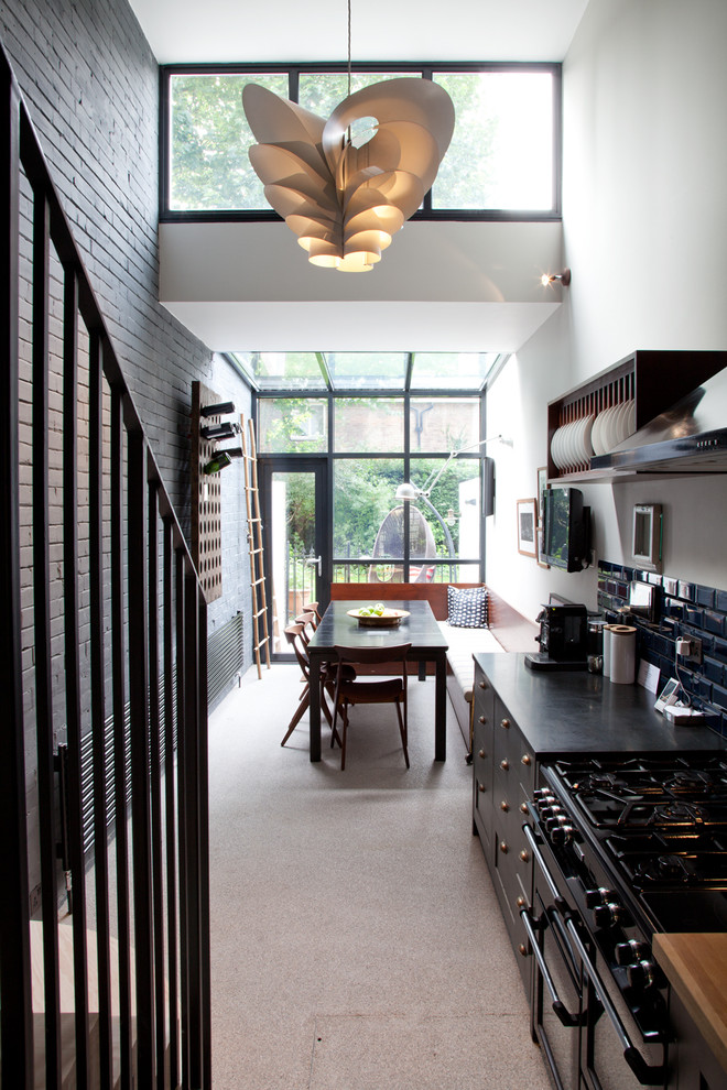 ロンドンにあるインダストリアルスタイルのおしゃれなキッチン (青いキッチンパネル、サブウェイタイルのキッチンパネル、黒い調理設備) の写真
