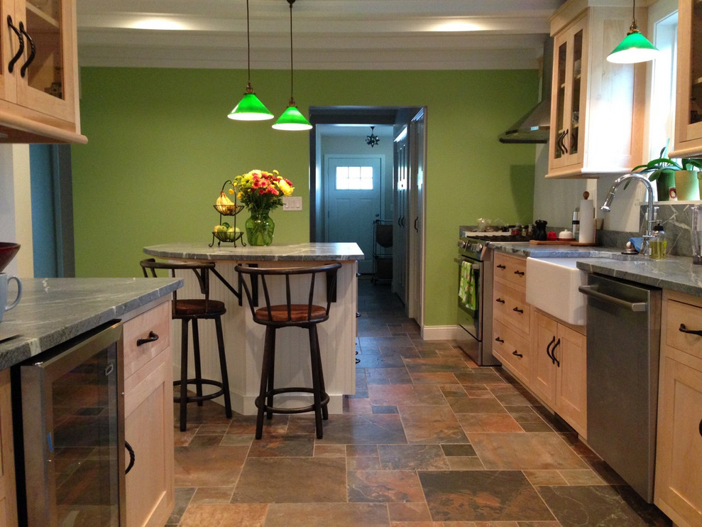 Example of a mid-sized arts and crafts l-shaped ceramic tile and multicolored floor enclosed kitchen design with a farmhouse sink, shaker cabinets, light wood cabinets, soapstone countertops, white backsplash, subway tile backsplash, stainless steel appliances, an island and gray countertops