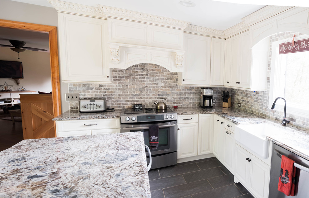 Small country l-shaped cement tile floor and gray floor eat-in kitchen photo in Philadelphia with a farmhouse sink, raised-panel cabinets, white cabinets, granite countertops, multicolored backsplash, stone tile backsplash, stainless steel appliances and an island