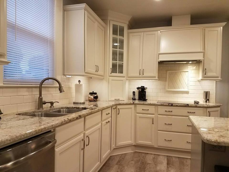 Example of a mid-sized classic u-shaped vinyl floor eat-in kitchen design in Raleigh with an undermount sink, flat-panel cabinets, beige cabinets, granite countertops, beige backsplash, porcelain backsplash, stainless steel appliances and an island
