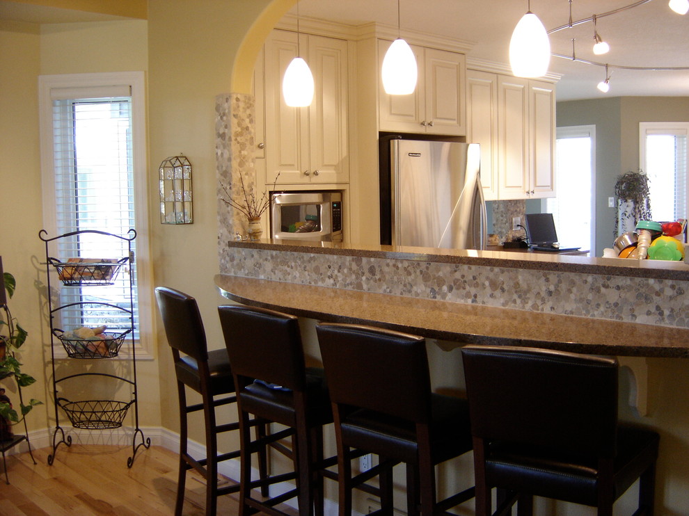 Immagine di una cucina classica con lavello sottopiano, ante con bugna sagomata, ante beige, top in quarzo composito, paraspruzzi multicolore e elettrodomestici in acciaio inossidabile