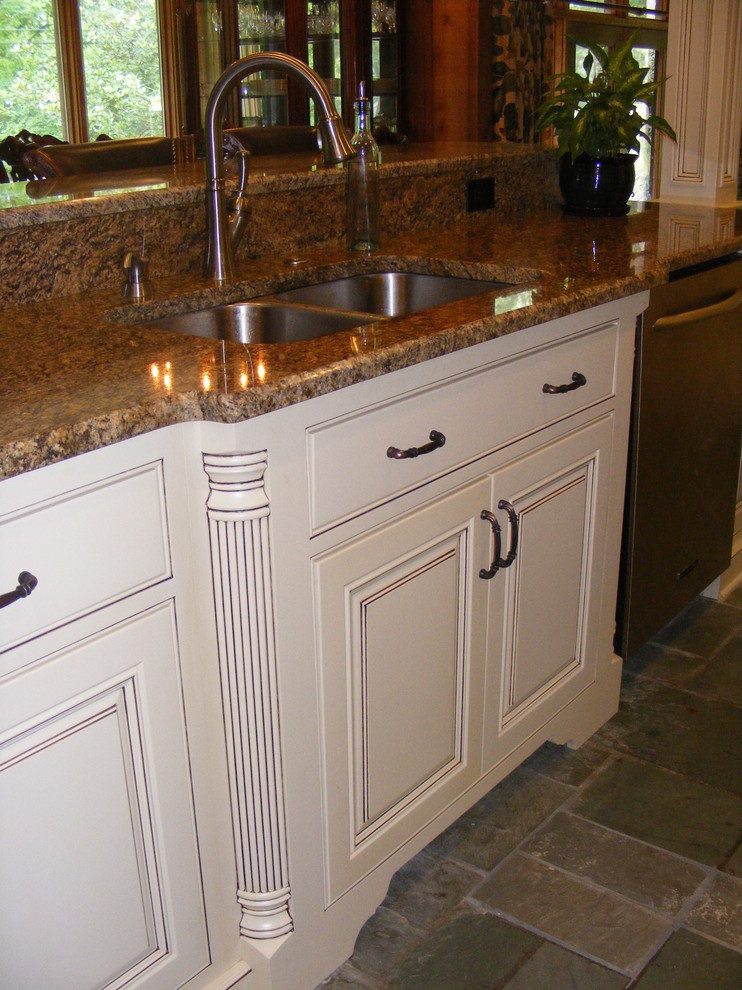 Esempio di una cucina classica con lavello sottopiano, ante a filo, ante beige, top in granito, paraspruzzi beige, paraspruzzi con piastrelle in pietra e elettrodomestici in acciaio inossidabile