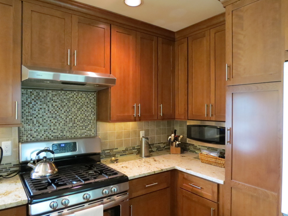 Elegant u-shaped eat-in kitchen photo in Detroit with an undermount sink, shaker cabinets, medium tone wood cabinets, granite countertops, brown backsplash, porcelain backsplash and stainless steel appliances