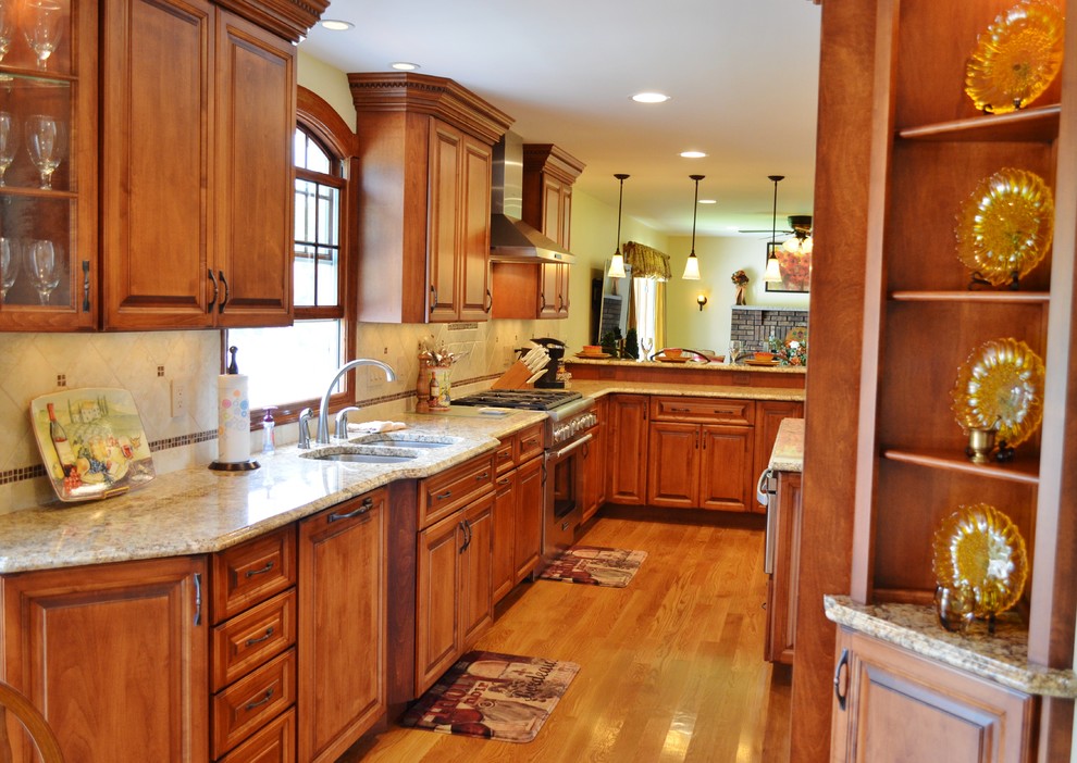 Exempel på ett mycket stort klassiskt kök, med en dubbel diskho, luckor med upphöjd panel, skåp i mellenmörkt trä, granitbänkskiva, beige stänkskydd, stänkskydd i keramik, rostfria vitvaror, mellanmörkt trägolv och en köksö