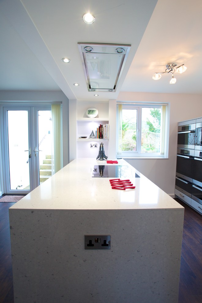Foto på ett litet funkis kök, med en undermonterad diskho, släta luckor, grå skåp, bänkskiva i koppar, grått stänkskydd, rostfria vitvaror och en köksö