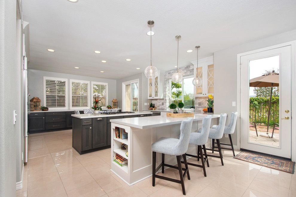 Inspiration for a large timeless u-shaped porcelain tile and beige floor open concept kitchen remodel in San Diego with an undermount sink, shaker cabinets, white cabinets, quartz countertops, gray backsplash, marble backsplash, paneled appliances, an island and gray countertops