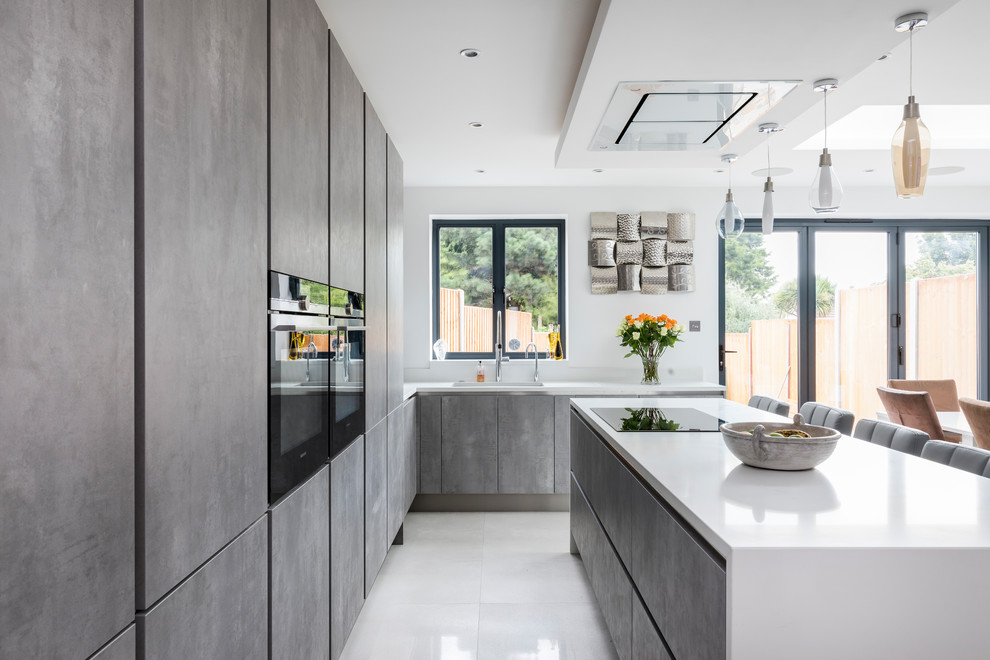 This is an example of a medium sized contemporary grey and white kitchen/diner in Other with flat-panel cabinets, distressed cabinets, quartz worktops, integrated appliances, an island and white floors.