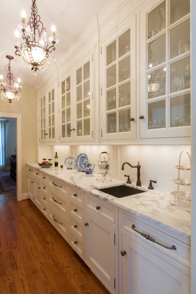 セントルイスにある広いトラディショナルスタイルのおしゃれなキッチン (ガラス扉のキャビネット、白いキャビネット、大理石カウンター、白いキッチンパネル、パネルと同色の調理設備、無垢フローリング) の写真
