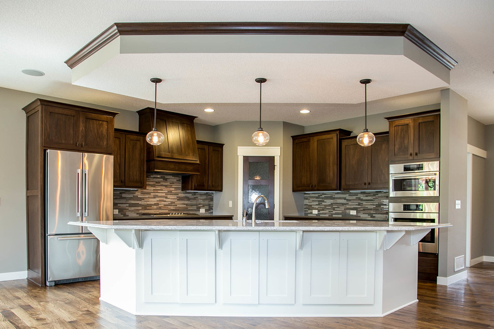 Eat-in kitchen - traditional l-shaped medium tone wood floor eat-in kitchen idea in Minneapolis with an undermount sink, recessed-panel cabinets, medium tone wood cabinets, quartz countertops, gray backsplash, ceramic backsplash, stainless steel appliances and an island