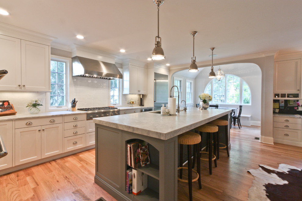 Elegant open concept kitchen photo in Newark with shaker cabinets, white cabinets, marble countertops, white backsplash and stainless steel appliances