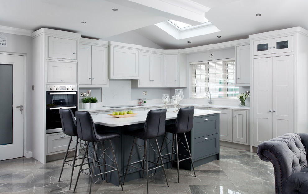Photo of a medium sized classic l-shaped open plan kitchen in Dublin with white cabinets, white splashback, grey floors, white worktops, beaded cabinets and an island.