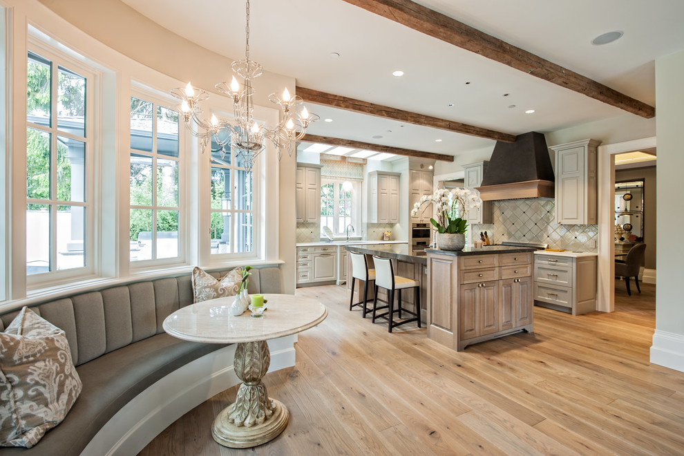 Inspiration for a large timeless l-shaped medium tone wood floor eat-in kitchen remodel in Vancouver with an undermount sink, raised-panel cabinets, gray cabinets, granite countertops, gray backsplash, ceramic backsplash, stainless steel appliances and an island