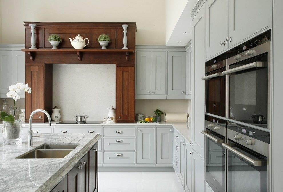 This is an example of a large classic open plan kitchen in Hertfordshire with shaker cabinets, grey cabinets and an island.