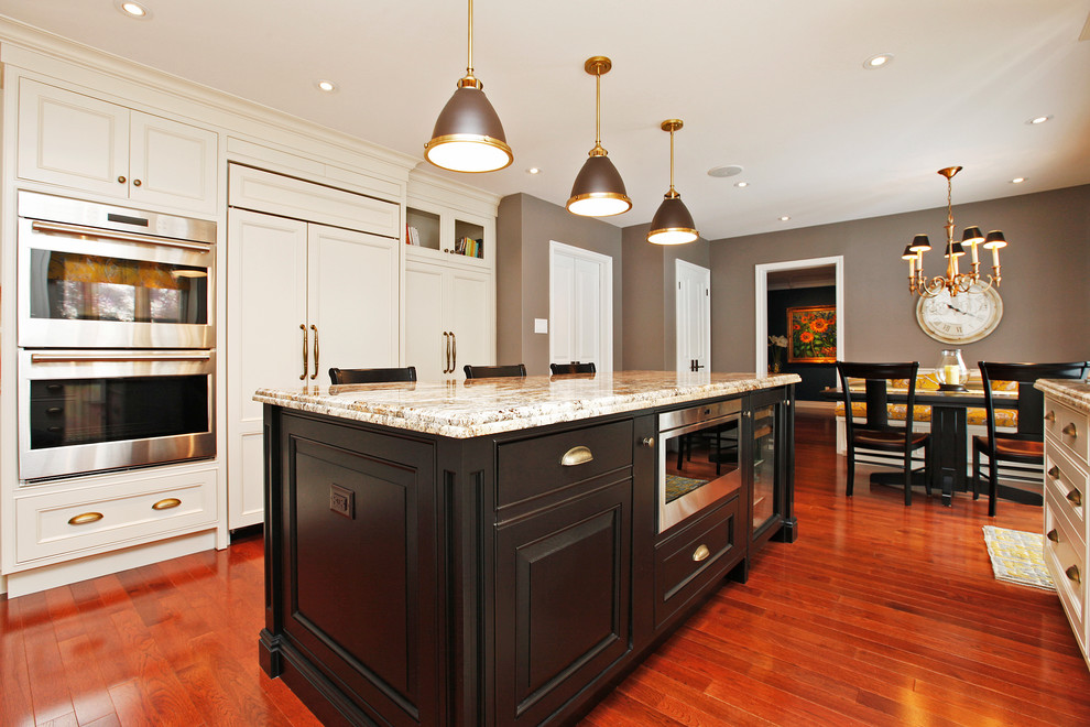 Inspiration for a large transitional u-shaped medium tone wood floor and brown floor eat-in kitchen remodel in Toronto with a farmhouse sink, raised-panel cabinets, white cabinets, granite countertops, yellow backsplash, marble backsplash, paneled appliances and an island