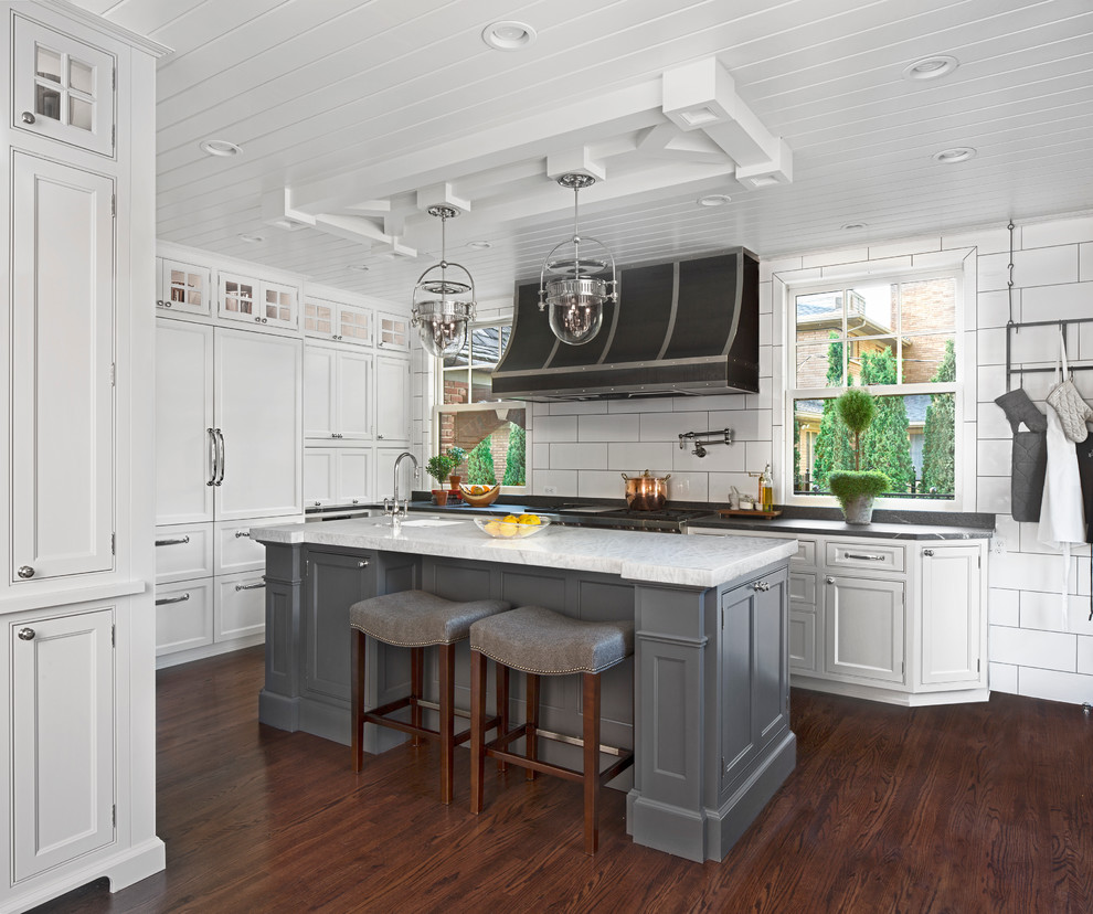 Klassische Küche in U-Form mit Kassettenfronten, weißen Schränken, Küchenrückwand in Weiß, dunklem Holzboden und Kücheninsel in Detroit