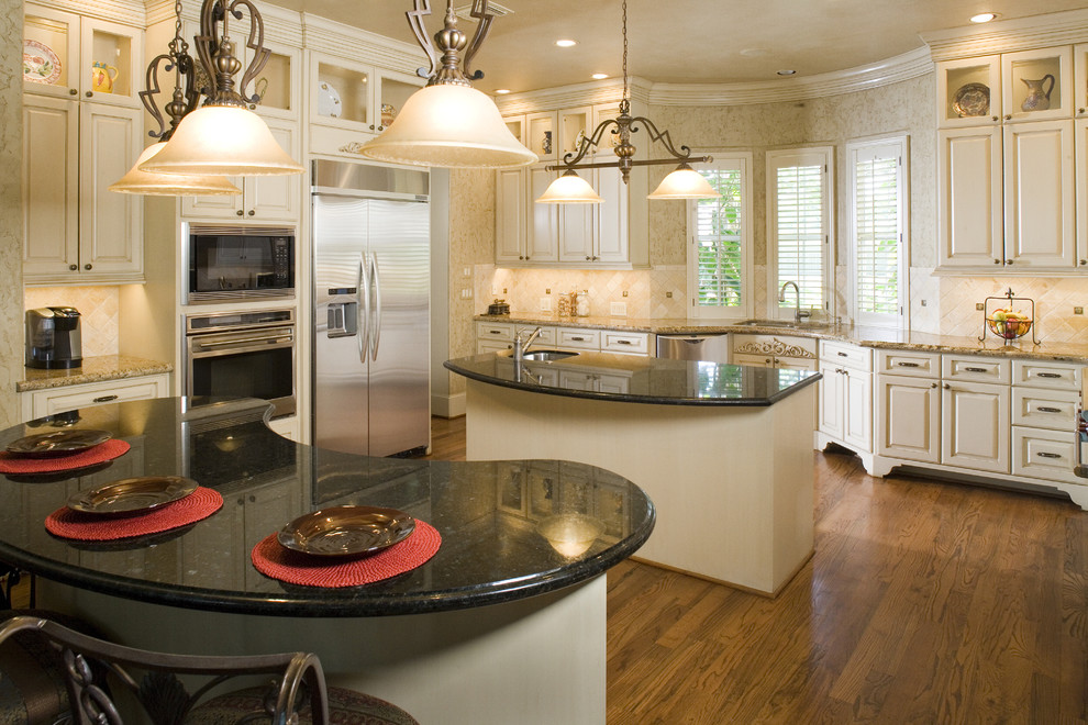 Example of a classic kitchen design in Houston with raised-panel cabinets, beige cabinets, beige backsplash and stainless steel appliances