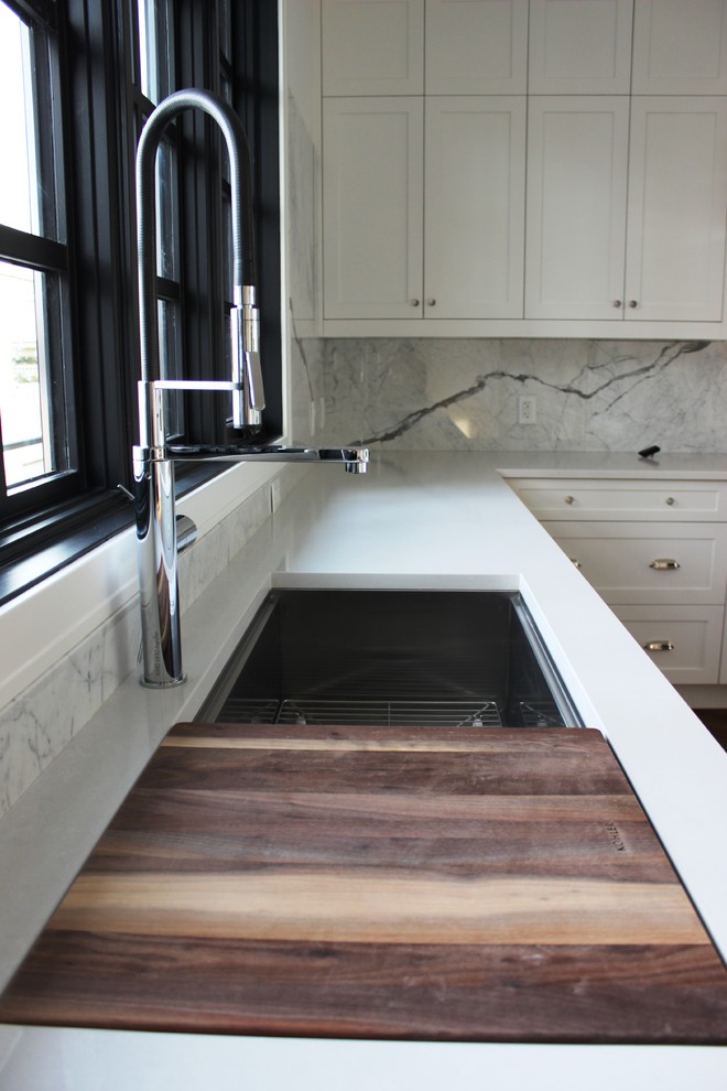 Large elegant l-shaped medium tone wood floor eat-in kitchen photo in Calgary with a single-bowl sink, shaker cabinets, white cabinets, quartz countertops, gray backsplash, stone slab backsplash, stainless steel appliances and an island