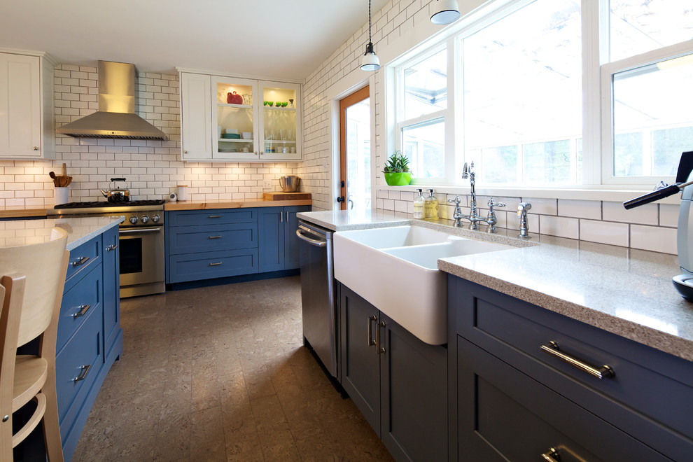 Design ideas for a medium sized farmhouse l-shaped open plan kitchen in Vancouver with a belfast sink, shaker cabinets, blue cabinets, quartz worktops, white splashback, metro tiled splashback, stainless steel appliances, cork flooring and an island.