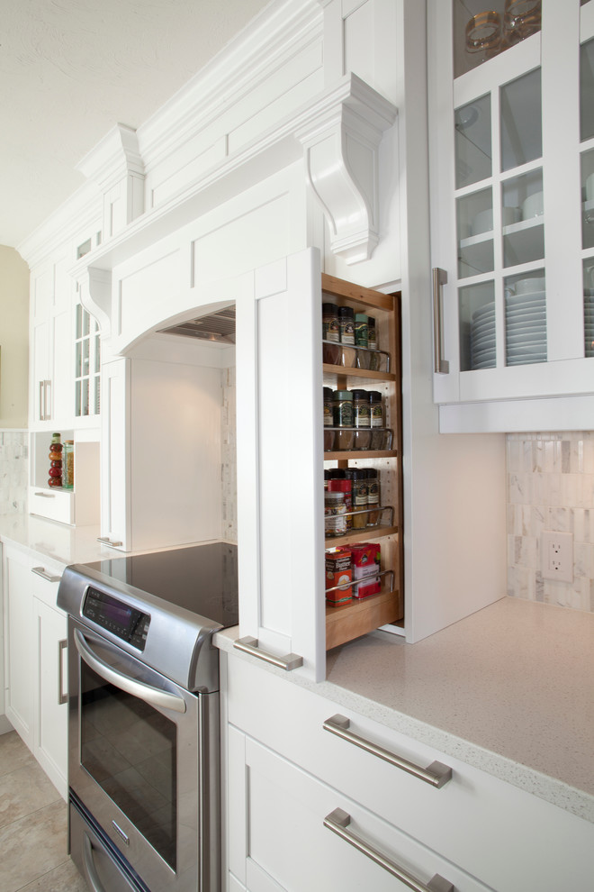 Foto på ett mellanstort vintage kök, med en undermonterad diskho, skåp i shakerstil, vita skåp, bänkskiva i kvarts, grått stänkskydd, stänkskydd i mosaik, rostfria vitvaror, klinkergolv i porslin och en köksö