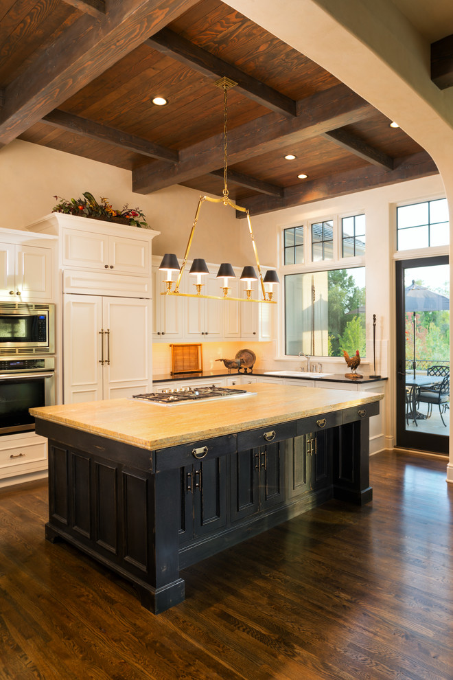 Inspiration for a large timeless u-shaped dark wood floor open concept kitchen remodel in Minneapolis with a drop-in sink, paneled appliances, recessed-panel cabinets, white cabinets, solid surface countertops, white backsplash, subway tile backsplash and an island
