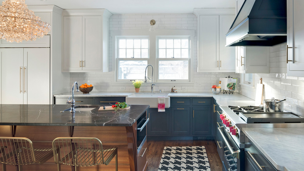 Foto på ett avskilt eklektiskt vit l-kök, med en rustik diskho, släta luckor, grå skåp, marmorbänkskiva, vitt stänkskydd, stänkskydd i tunnelbanekakel, rostfria vitvaror, mellanmörkt trägolv, en köksö och brunt golv
