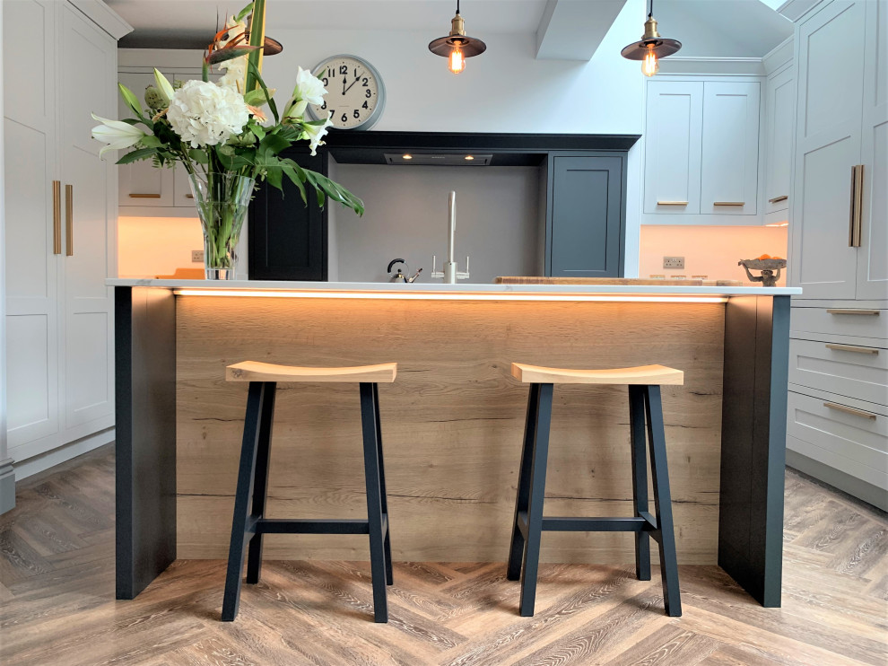 Foto di una cucina minimal di medie dimensioni con lavello a vasca singola, ante in stile shaker, ante in legno scuro, top in quarzite, elettrodomestici neri e pavimento in vinile