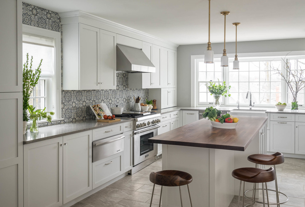 Klassische Küche mit Landhausspüle, Schrankfronten im Shaker-Stil, weißen Schränken, bunter Rückwand, Küchengeräten aus Edelstahl, Kücheninsel und grauem Boden in Boston