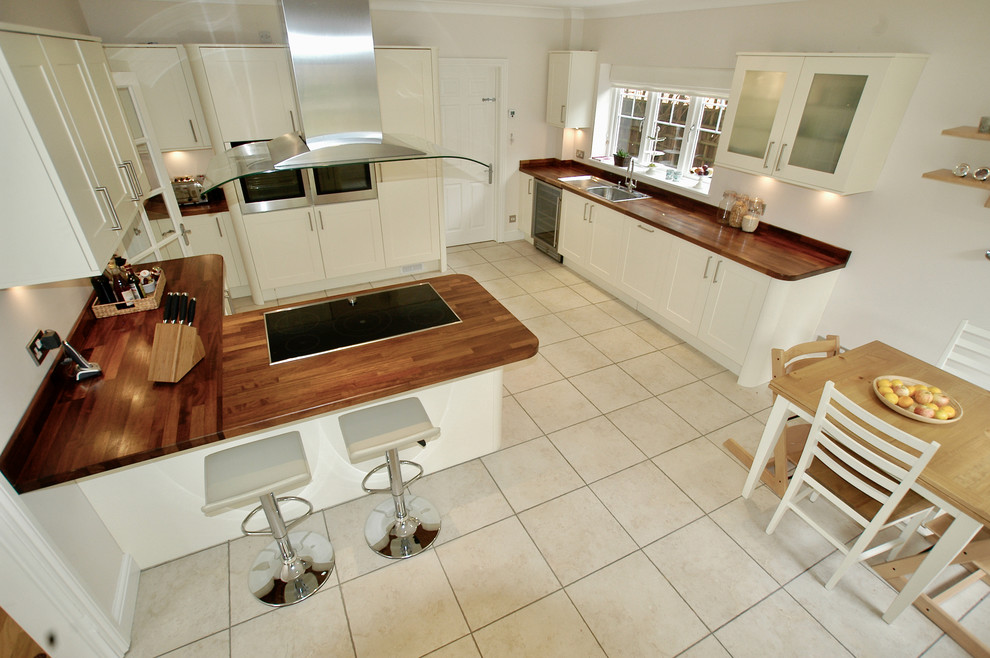 Foto på ett mycket stort funkis brun kök, med en nedsänkt diskho, skåp i shakerstil, gula skåp, träbänkskiva, brunt stänkskydd, rostfria vitvaror, klinkergolv i porslin, en halv köksö och beiget golv