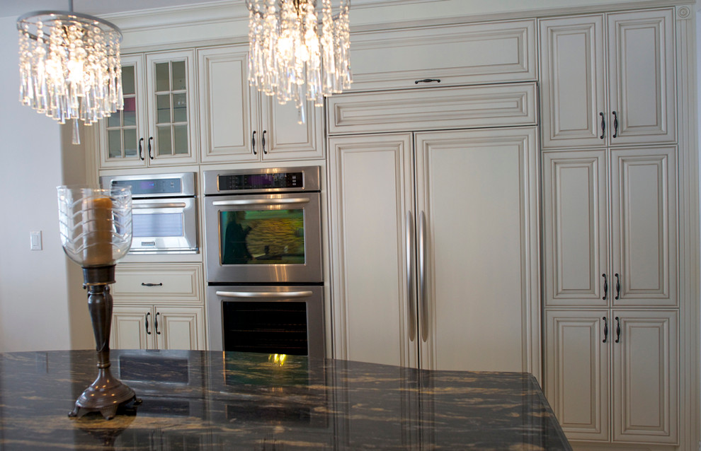 Photo of a large classic u-shaped kitchen/diner in Toronto with a submerged sink, raised-panel cabinets, white cabinets and granite worktops.