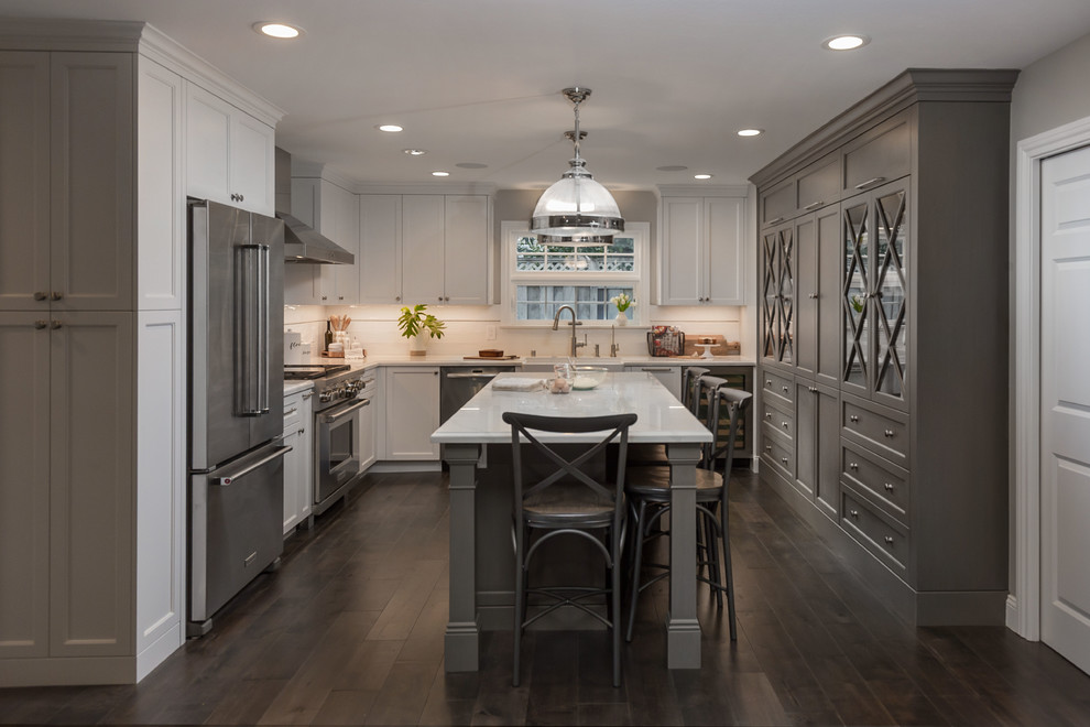 Inspiration for a large transitional galley medium tone wood floor and brown floor eat-in kitchen remodel in San Francisco with an undermount sink, glass-front cabinets, gray cabinets, quartz countertops, blue backsplash, ceramic backsplash, stainless steel appliances, an island and white countertops