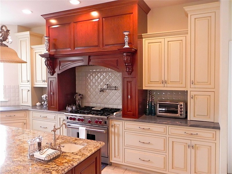 This is an example of a medium sized mediterranean u-shaped kitchen/diner in Philadelphia with white cabinets, white splashback, stainless steel appliances and an island.